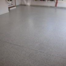 A garage floor with a gray speckled finish.