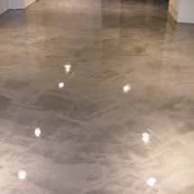 A metallic floor with white lights shining on it.