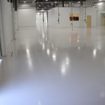A white floor in an industrial building with lights.