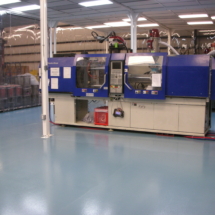 A machine in a factory with blue floors