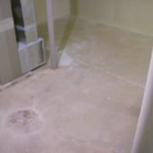 A bathroom floor that has been cleaned and is dirty.