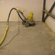 A concrete floor being cleaned with a machine.