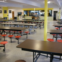A cafeteria with tables and chairs in it