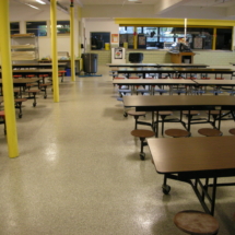 A cafeteria with tables and chairs in it