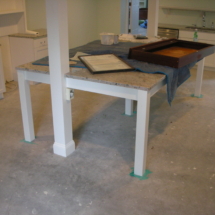 A table that is under construction in the middle of a room.