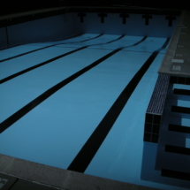 A swimming pool with blue water and black lines.