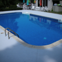 A pool with blue water and white tile around it.