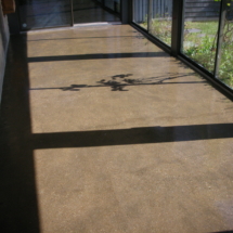 A walkway with shadows of the sun on it.