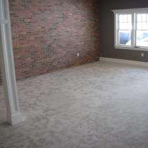 A room with brick walls and white carpet.