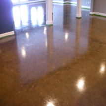 A room with brown stained concrete floors and green lines.