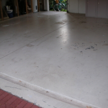 A garage floor with some dirt on it