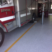 A fire truck parked in the garage of a building.