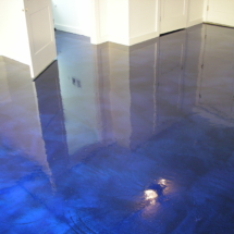 A blue floor with a reflection of the ground.