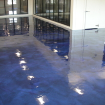 A blue floor with water on it and reflections