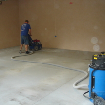 A man is cleaning the floor of his garage.