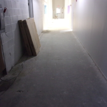 A hallway with a white wall and some boxes