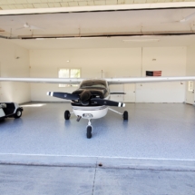 A small airplane parked in the middle of an empty garage.